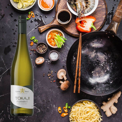 Flasche Tokaji Furmint Weißwein neben Zutaten für asiatisches Gericht mit Garnelen, Paprika, Pilzen, Nudeln, Sojasauce